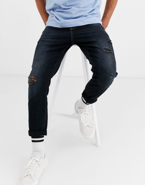 ASOS DESIGN tapered jeans in washed black with abrasions